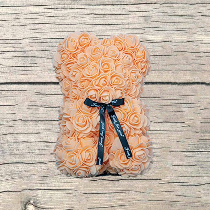 Ourson mousse en roses pèches artificielles dans sa boite.