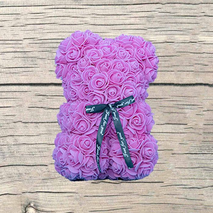 Ourson mousse en roses roses artificielles dans sa boite.