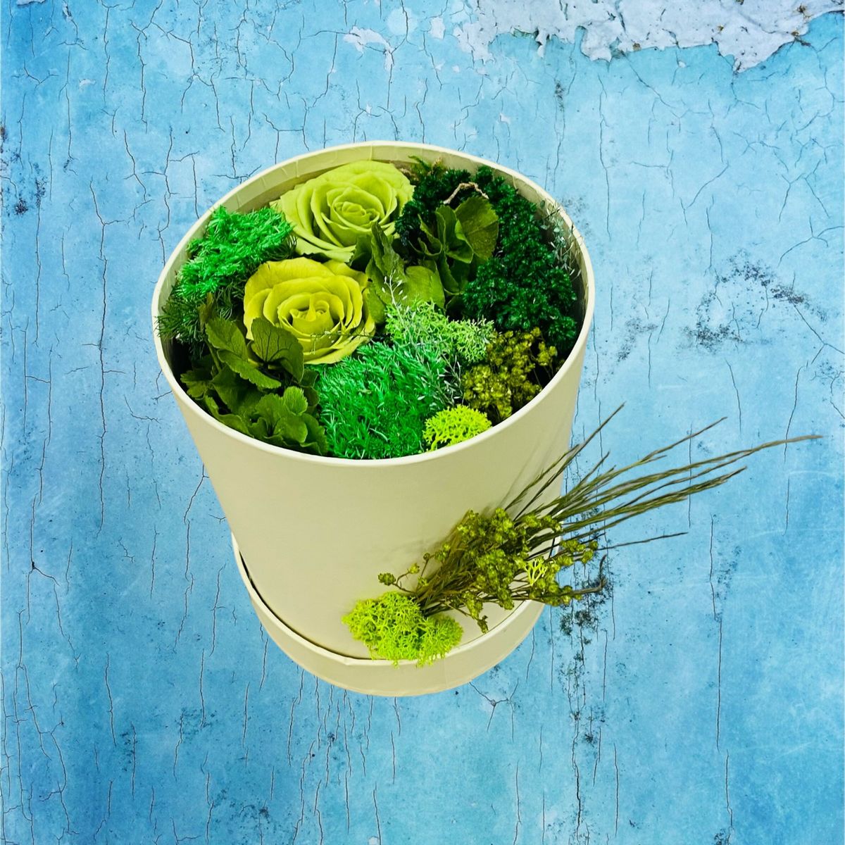 Boîte à chapeau composée de fleurs stabilisées et séchées vertes